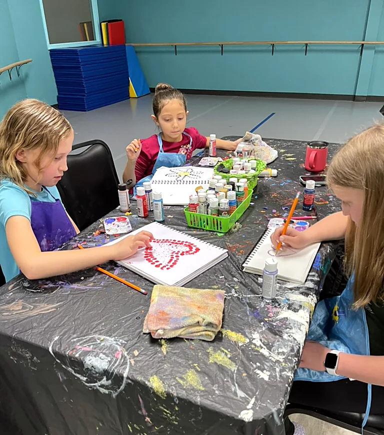 Young artists painting together at an ArtHaus table