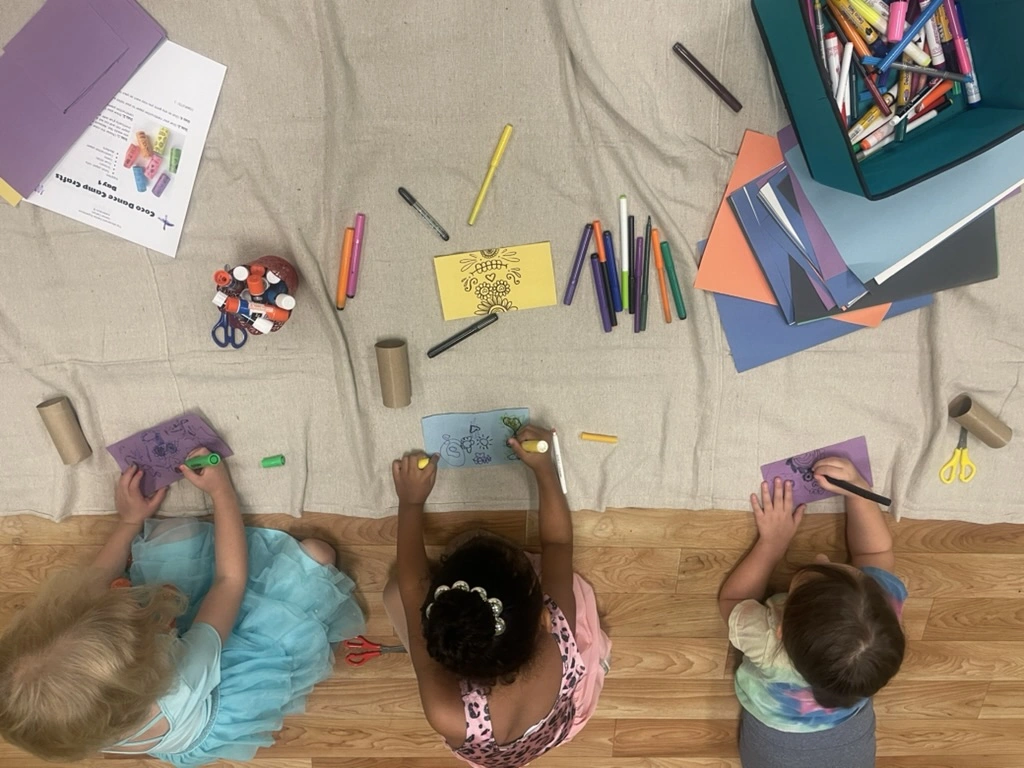 Campers coloring Coco-themed crafts during summer dance camp
