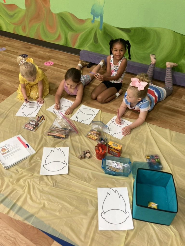 Campers coloring Trolls crafts during summer dance camp