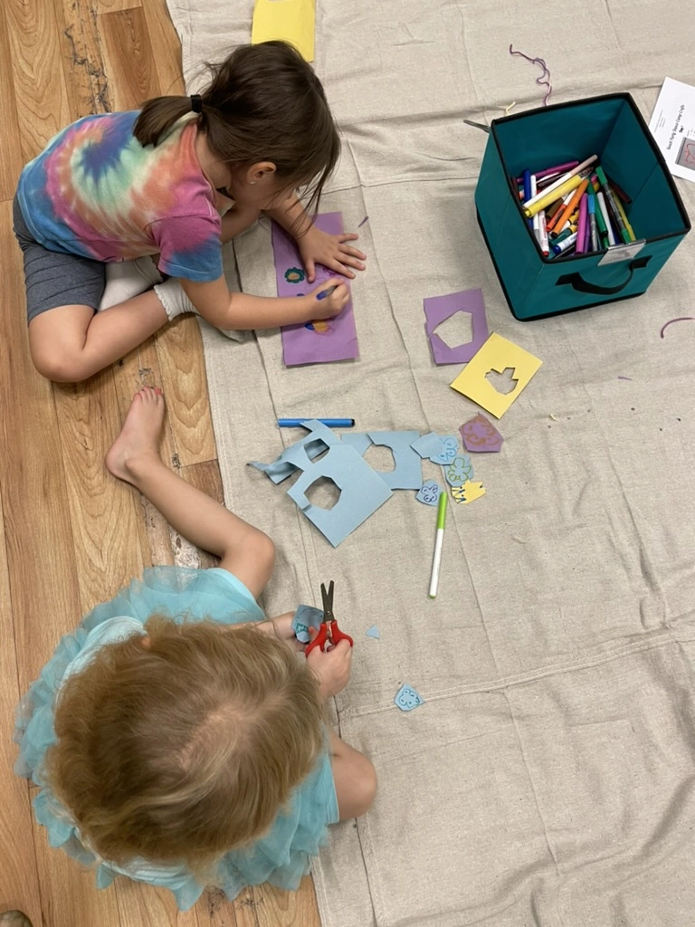 Campers cutting and coloring paper crafts at summer camp