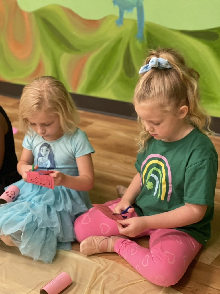 Two summer campers cutting paper during craft time