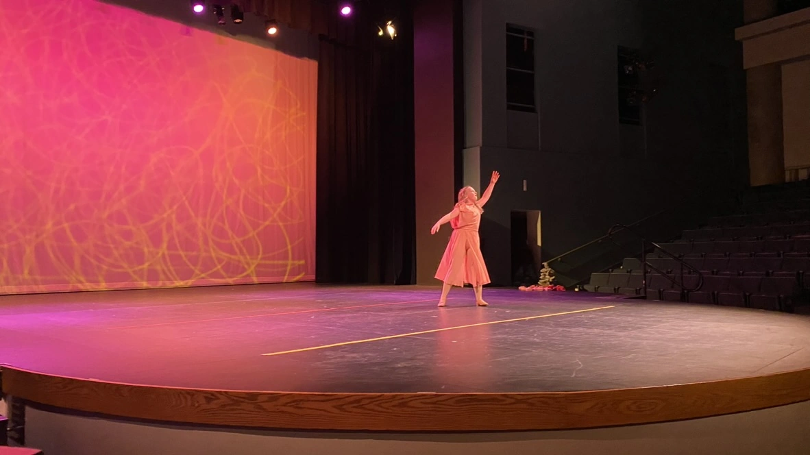 A company dancer performing a lyrical solo in a peach dress