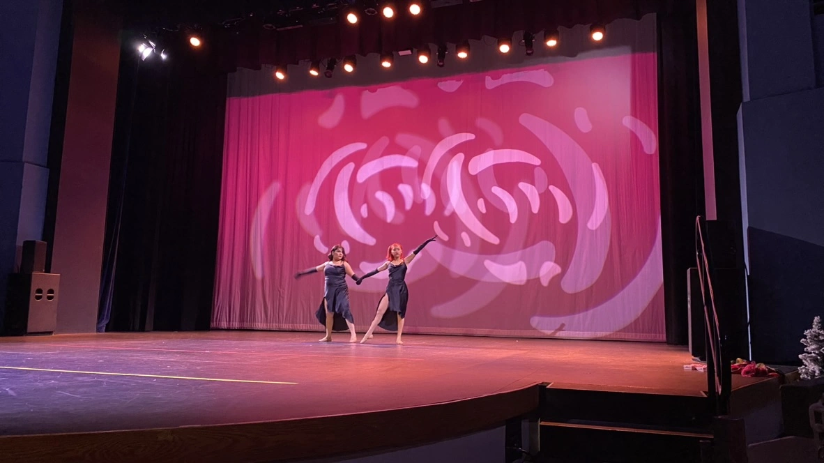 Two company dancers in black gowns performing a lyrical duet