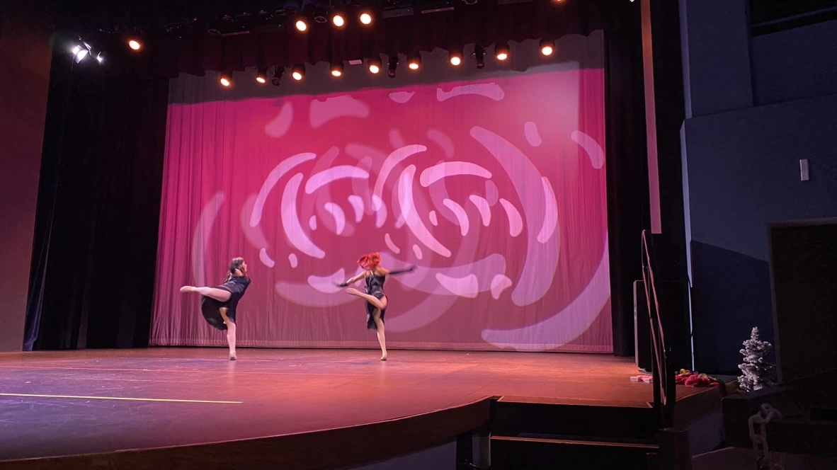 Company duet dancers kicking high on stage