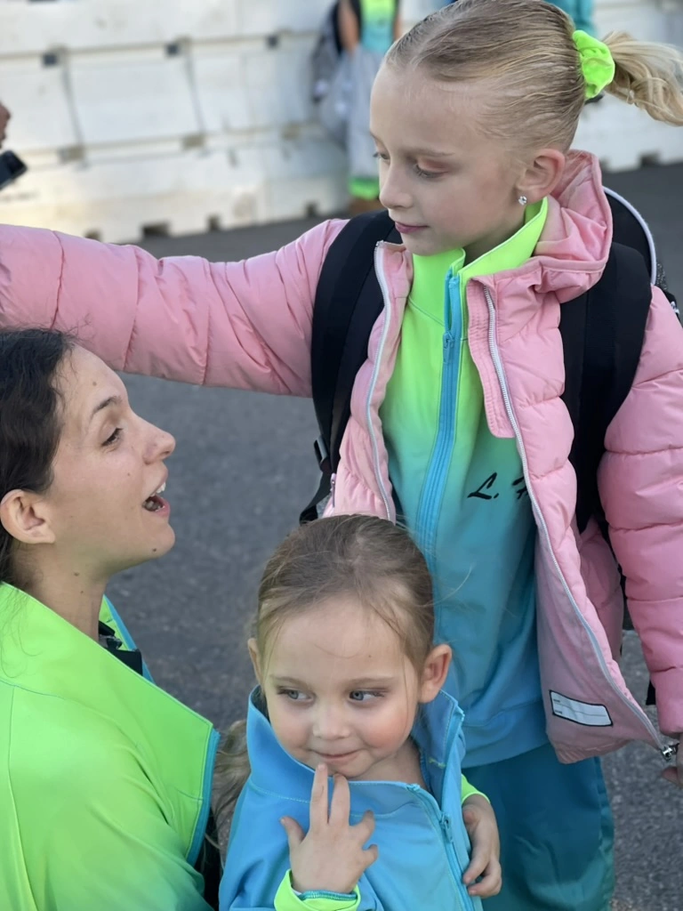 A Movement teacher with young company dancers in team jackets