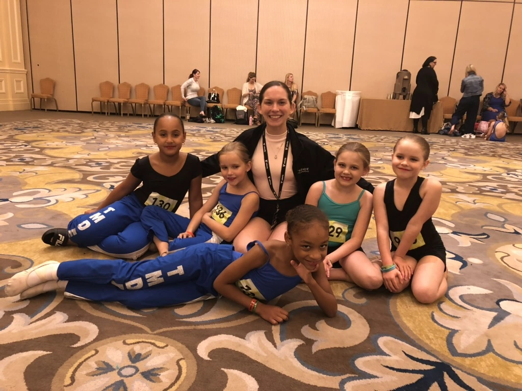Young company dancers in TMDE warm-ups with their teacher at a dance convention