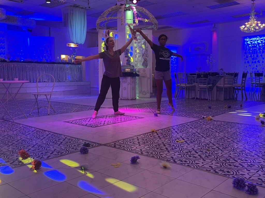 A Movement coach rehearsing choreography one-on-one with a dancer in an event ballroom