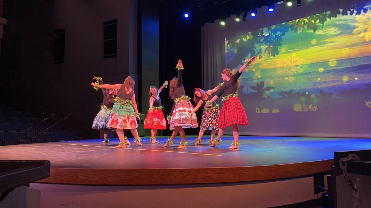 Adult Encore dancers performing a holiday hula number at Ovation Theatre