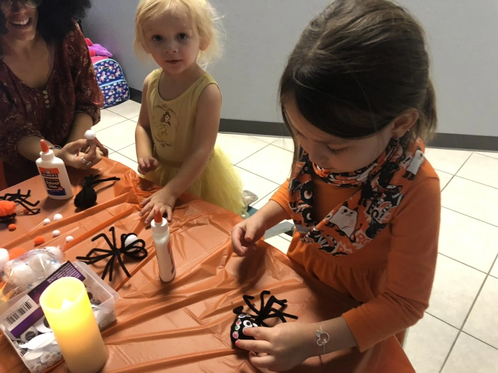 Little dancers making pipe-cleaner spiders at a Movement Halloween party