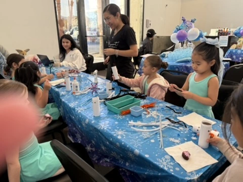 Kids making winter crafts with a Movement teacher at a holiday party