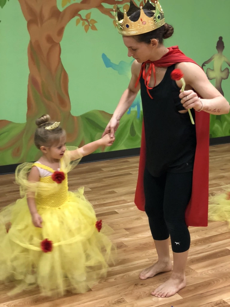 A teacher dressed as the Beast dancing with a tiny Belle