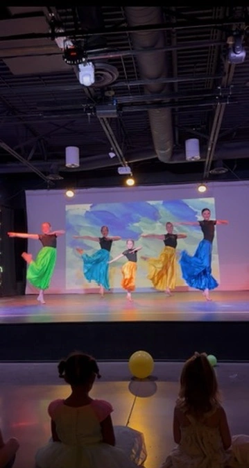 Dancers in bright flowing skirts performing at Ovation Theatre