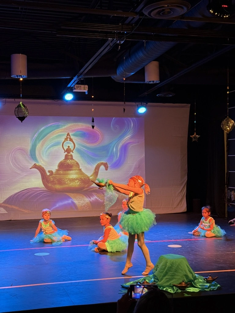 Little genies in colorful tutus dancing around a golden lamp at a Once Upon A Ballet Aladdin show