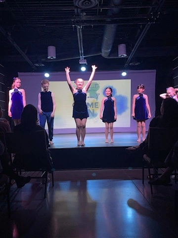 Dancers in navy costumes finishing a number at Ovation Theatre