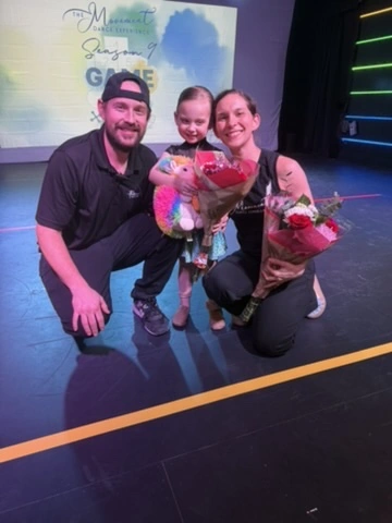 Seth and Mandy celebrating a young dancer with flowers on the Ovation Theatre stage after Season 9 Game On
