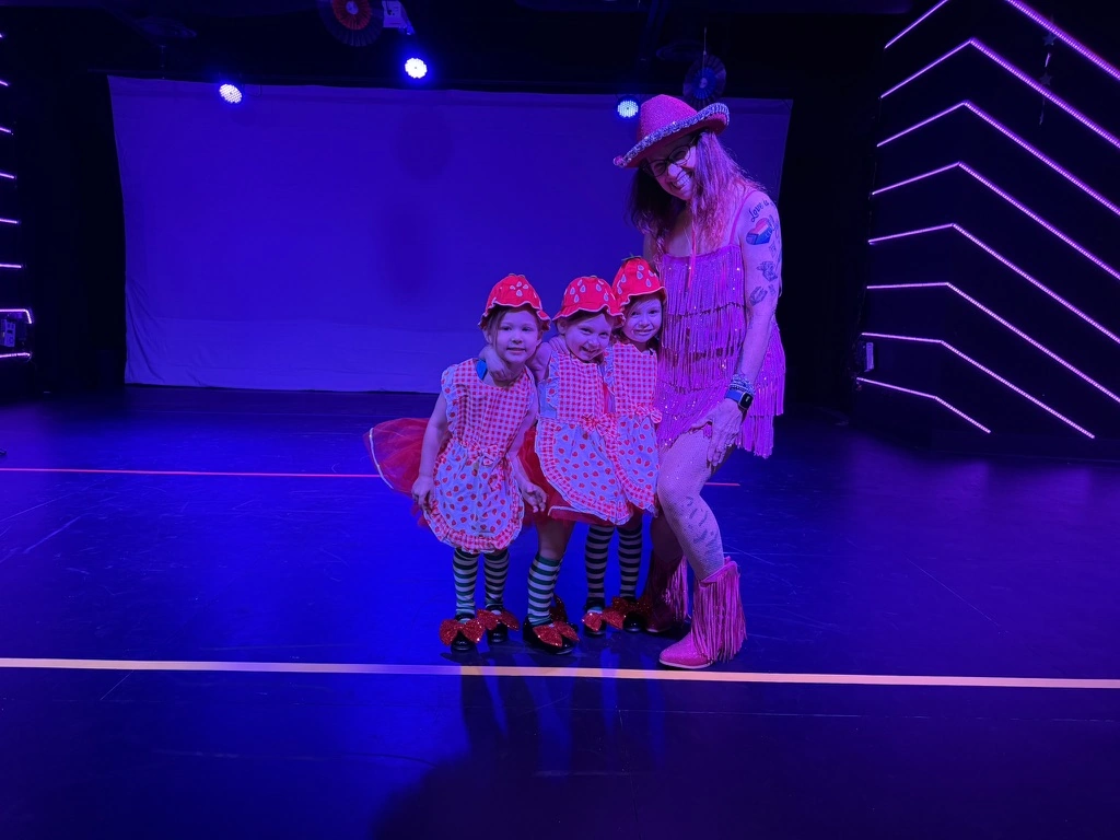 Three little strawberry dancers with their teacher on the Ovation Theatre stage