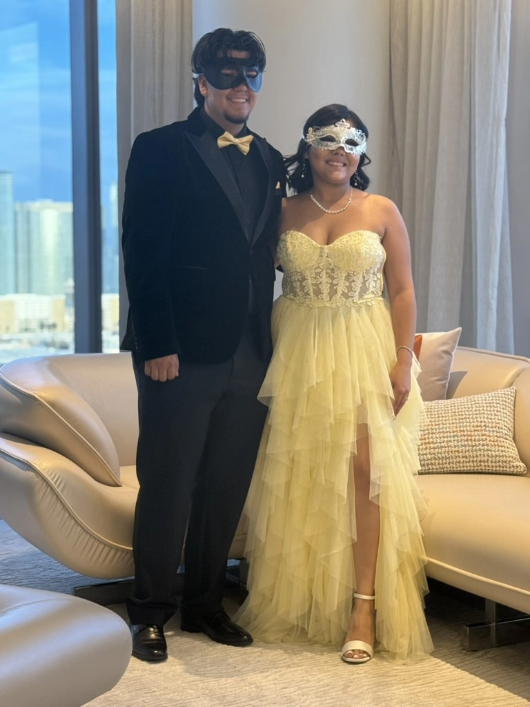 A couple dressed for a masquerade formal, ready to dance